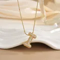 Macro shot of gold letter I pendant with micro-paved zircons on elegant snake chain - Letter I