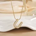 Macro shot of 18K gold plated U-shaped pendant necklace featuring pave-set cubic zirconia - Letter U