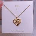 Collar de corazón dorado con cristales blancos y grabado 'MOM' en tarjeta joya - Corazón Manos Entrelazadas Dorado (MOM17)
