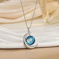 Detail van zilveren halve maan ketting met blauwe sterrennevel bol op zijden ondergrond - Blauwe Nevel Werveling Stijl (XL0634B)