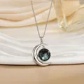 Gedetailleerde close-up van een zilveren maan-halsketting met een blauwe sterrenstelsel - Blauw Zwart Sterrenhemel Stijl (XL0636G)