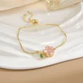 Dettaglio del ciondolo fiore di ciliegio rosa su catena dorata con chiusura bolo regolabile - Bracciale Sakura Rosa Oro (SL0125)