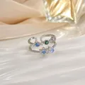 Dettaglio di anelli floreali in argento regolabili con pietre colorate su seta - Stile Petalo Multicolore (JZ0121G)