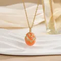 Detail of coral orange egg pendant with gold V-pattern and sparkling zircons - Coral Orange V-Shape Rhinestone Style (XL0651)