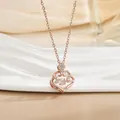 Details einer roségoldenen Kleeblatt-Halskette mit Herzanhänger und Scroll-Mustern - Tanzendes Hohles Herz Stil / Roségold