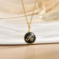 Macro detail of gold disk pendant with black enamel inlay and Fe engraving - Gold Round Black Enamel Letter Heart (XL1104B)
