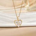 Macro shot of gold heart pendant with white enamel and Fé engraving on a gold chain - Gold Heart White Enamel Letter (XL1105)