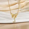 Macro detail of golden bow necklace featuring a sparkling letter J pendant with zircons - Letter J