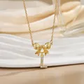 Detailed close-up of bow knot necklace with zircon letter L pendant in gold - Letter L