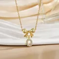 Detail of gold bow necklace with letter O pendant inlaid with zircon on ceramic tray - Letter O