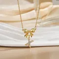 Macro shot of gold bow necklace with sparkling zircon Letter X pendant for women - Letter X