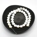 Macro detail of white flower-shaped natural shell beads with pearlescent luster for DIY jewelry - Five-Petal Flower