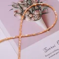 Gros plan de perles cylindriques 3x5mm en nacre orange-rose avec un fini perlé - N°1 (Rose Orangé)