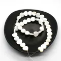 Natural white shell heart-shaped loose beads for DIY jewelry making on black display - Vertical Hole Heart Shape