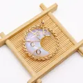 Detailed wire-wrapped moon pendant with opal-like stone in a golden woven circular frame - 42x50mm / Opal