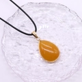 Detailaufnahme des Wassertropfen-Tigerauge-Anhängers mit Goldrand auf einer Glasbasis - 20x30mm / Topas