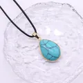 Makroaufnahme von Türkis-Wassertropfen-Anhänger mit vergoldetem Rand und schwarzer Kordel - 20x30mm / Blauer Türkis