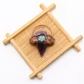 Detailweergave van handgemaakte amethist hanger met abalone schelp en koperen omlijsting - Amethist