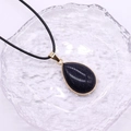 Tropfenförmiger Blaufluss-Anhänger mit vergoldeter Fassung an schwarzer Kordelkette - 20x30mm / Blauer Sandstein
