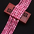 Detailed macro view of faceted pink cat eye stone oval beads on a wooden jewelry box - 4x6MM / No. 10 (Pink)