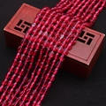 Detail van doorschijnende rozerode ovale kattenoogkralen op een vintage houten kistje - 4x6 / Rozerood