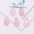 Macro detail van vijf facetgeslepen opaal druppelkralen voor DIY-sieraden maken - 13x25mm / Rozenkwarts