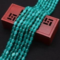 Gepolijste groenblauwe kattenoogsteen ovale kralen op een antiek houten juwelendoosje - Turquoise Groen
