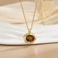 Detailed shot of gold heart pendant with tiger eye stone on a decorative ceramic tray - Irregular Tiger Eye Style (XL0687)