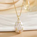 Detail of Fabergé style egg pendant with white enamel, floral gold filigree and crystals - White