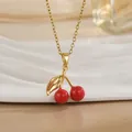 Gros plan d'un collier pendentif cerise avec émail rouge et chaîne dorée sur fond clair - Cerise Sphérique Rouge Vive (XL01172) / Or