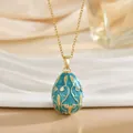 Detailed close-up of Russian style egg pendant with blue enamel and gold vine patterns - Cyan Blue