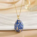 Close-up of blue enamel Fabergé style egg pendant with gold vine texture and crystals - Blue