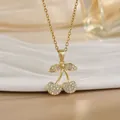 Vue macro d'un collier pendentif cerise dorée avec des zircons blancs sertis en micro-pavage - Style cerise pavé de strass (XL01190) / Or