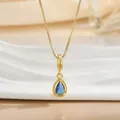 Close-up of a pear-shaped blue gemstone pendant with golden beaded trim on a box chain - Dark Blue Waterdrop Gem Necklace (XL01288)