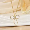 Elegante goldene Schleifen-Halskette mit Zirkonia-Anhängern auf Satin-Hintergrund - Schleife Band Stil (XL01353)