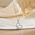 Detailed macro view of silver heart pendant necklace with shimmering crystals on silk - Silver Hollow Double Heart Rhinestone Style (XL01617G)
