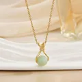 Detailed close-up of a green jade pendant necklace with gold chain and zircon accents - Light Green Round Bead (XL01481)