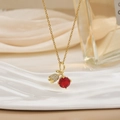 Close-up of gold chain necklace with red gemstone and zircon cherry pendant on silk - Deep Red Gem Cherry Style (XL0586)