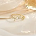 Détail d'une bague dorée ornée d'un papillon, de fleurs et de zircons brillants - Style Papillon Fleur Blanche (JZ0319)