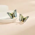Détail macro de boucles d'oreilles papillon aux ailes chatoyantes bleu-vert et zircons dorés - Style de Papillon Dégradé Onirique Émeraude Bleu Foncé (EH0114H)
