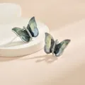 Détail macro des boucles d'oreilles papillon avec ailes dégradées bleu-vert et cristaux - Style de Papillon à Paillettes Dégradé Vert Foncé Gris Bleu (EH0114GH)