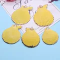 Détail de cinq pendentifs coquilles Saint-Jacques jaunes avec bords dorés sur fond bleu - Jaune