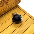 Polished black gemstone sphere pendant with silver claw setting on bamboo background - 19x28mm / Black Agate