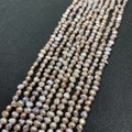Detailed view of natural lavender freshwater pearls in baroque shape on a dark texture background - Size Three To Four / Purple