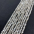 Close-up of white baroque freshwater pearls showing natural luster on black background - Size Three To Four / White
