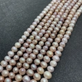 Macro detail of natural freshwater pearls in pink and purple hues on a textured dark background - 3-4mm (11g) / Purple
