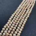 Macro shot of natural freshwater pearls showing pink luster and unique spiral textures - 5-6mm / Pink