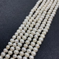 Macro detail of white freshwater pearl strands showing natural texture and baroque luster - 5-6mm / White