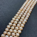 Macro detail of natural peach pink freshwater pearls on black leather background - 4-5mm / Pink