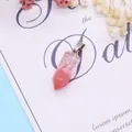 Macro detail of a hexagonal natural stone pendant with pink and white gradient patterns - 9x28mm / Watermelon Quartz